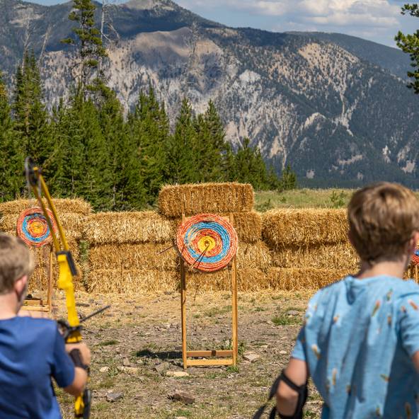Kids shooting arrows at a target