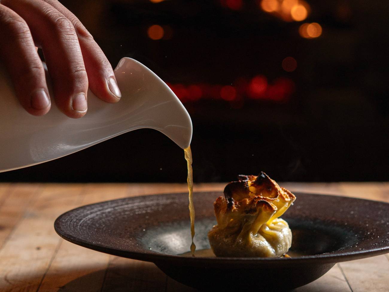 Dish being prepared in front of a fireplace