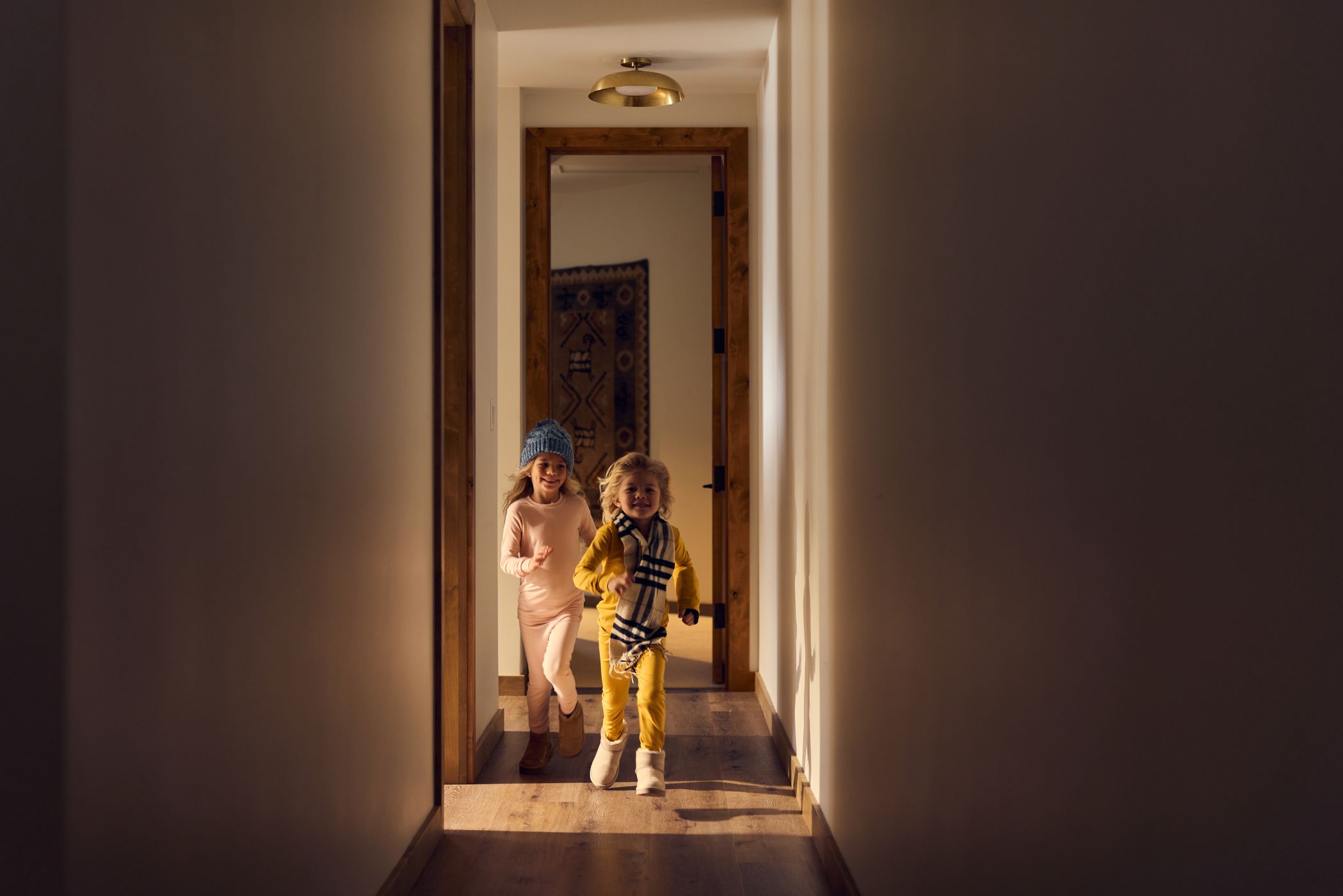 Kids running through a hallway in ski gear