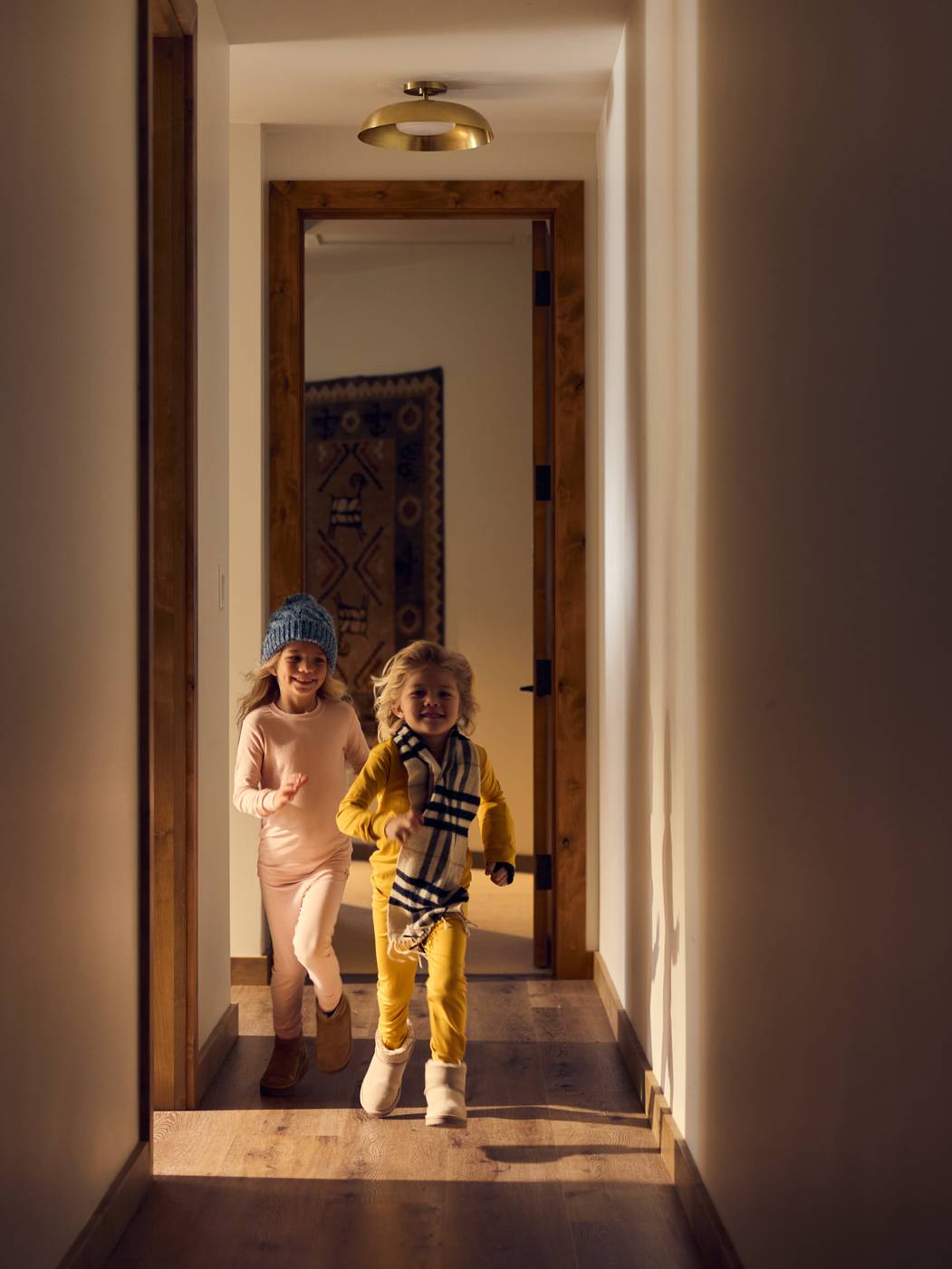 Kids running through a hallway in ski gear