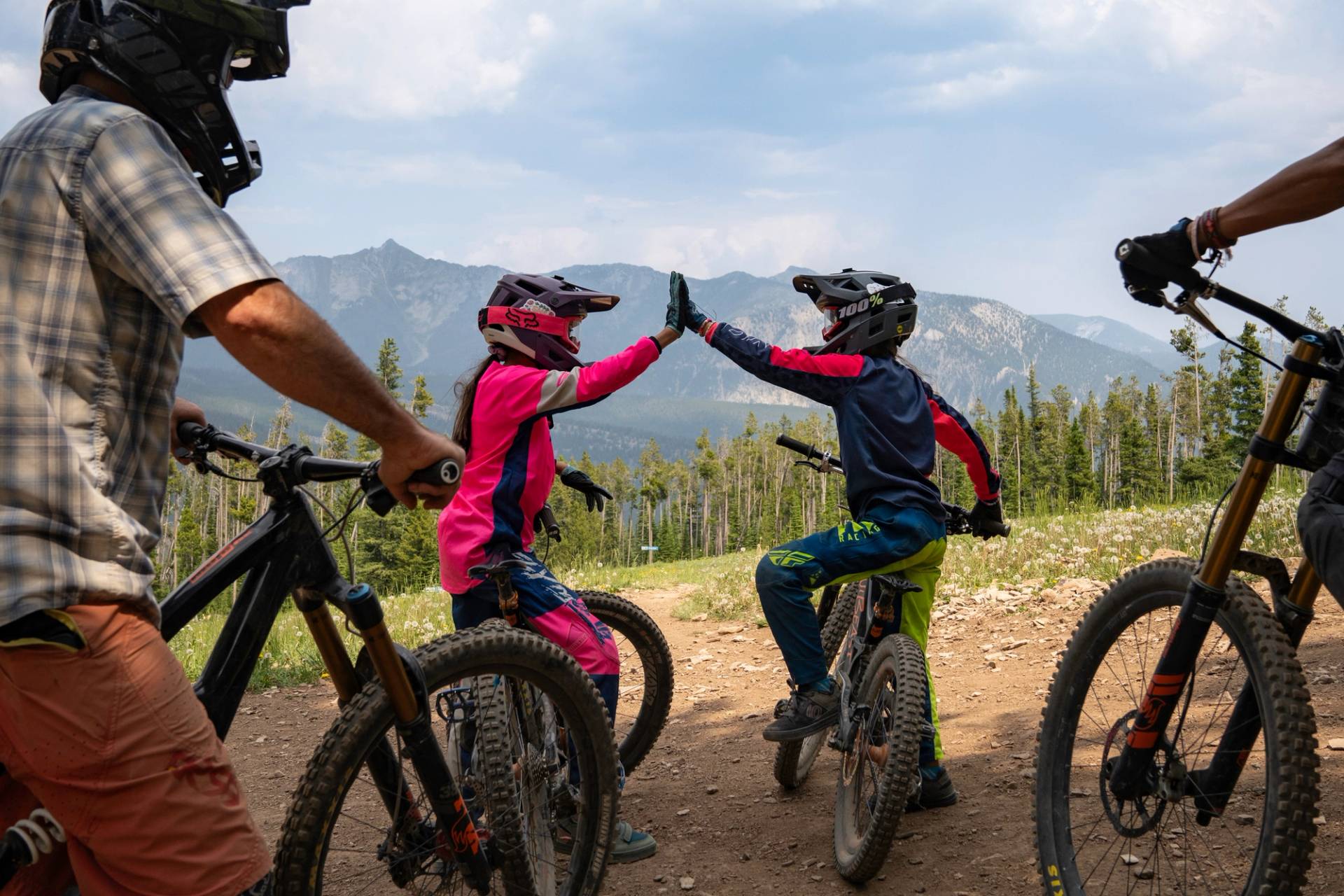 Two girls on their mountain bikes high-fiving
