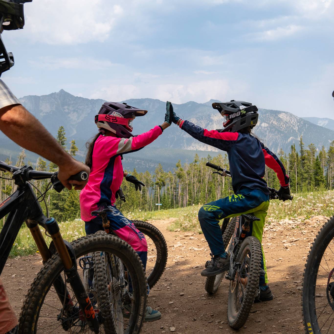 Two girls on mountain bikes high-fiving