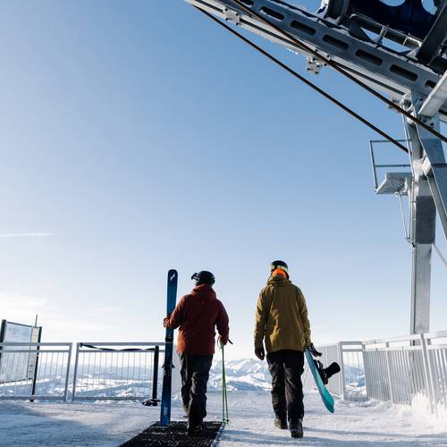 Skier and snowboarder at the top of t Lone Peak Tram