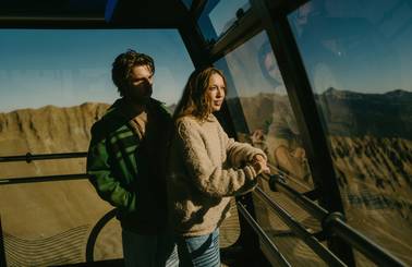 Two people looking out from the Lone Peak Tram