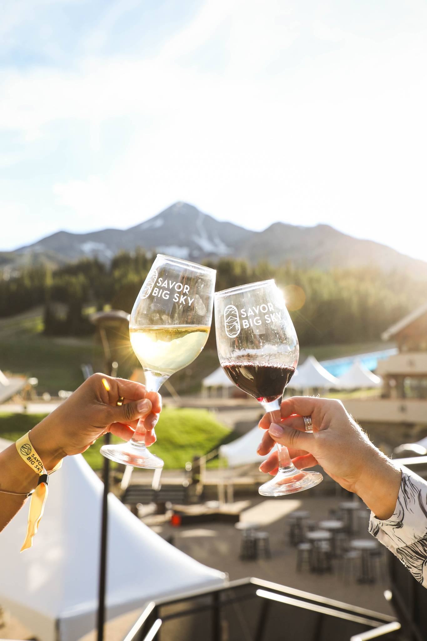 Wine glasses cheersing in front of Lone Peak