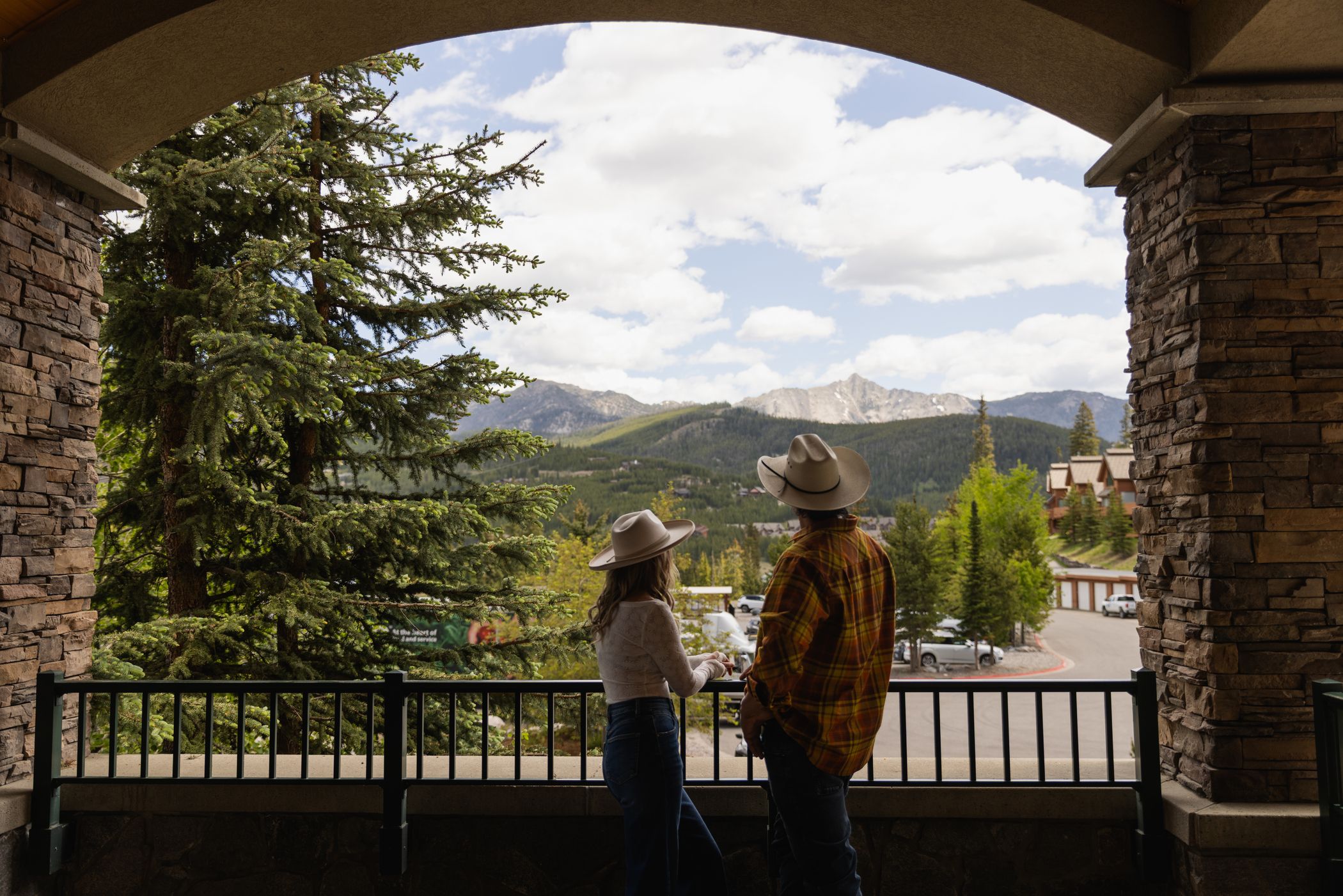 Couple looking out at the view of summer mountains from an archway