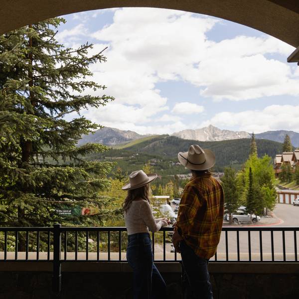 Couple looking out at the view of summer mountains from an archway