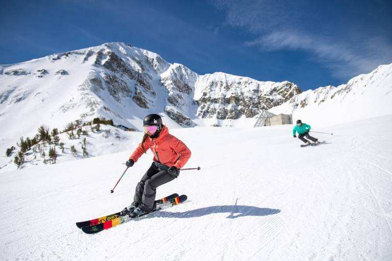 Two skiers carve down upper morning star