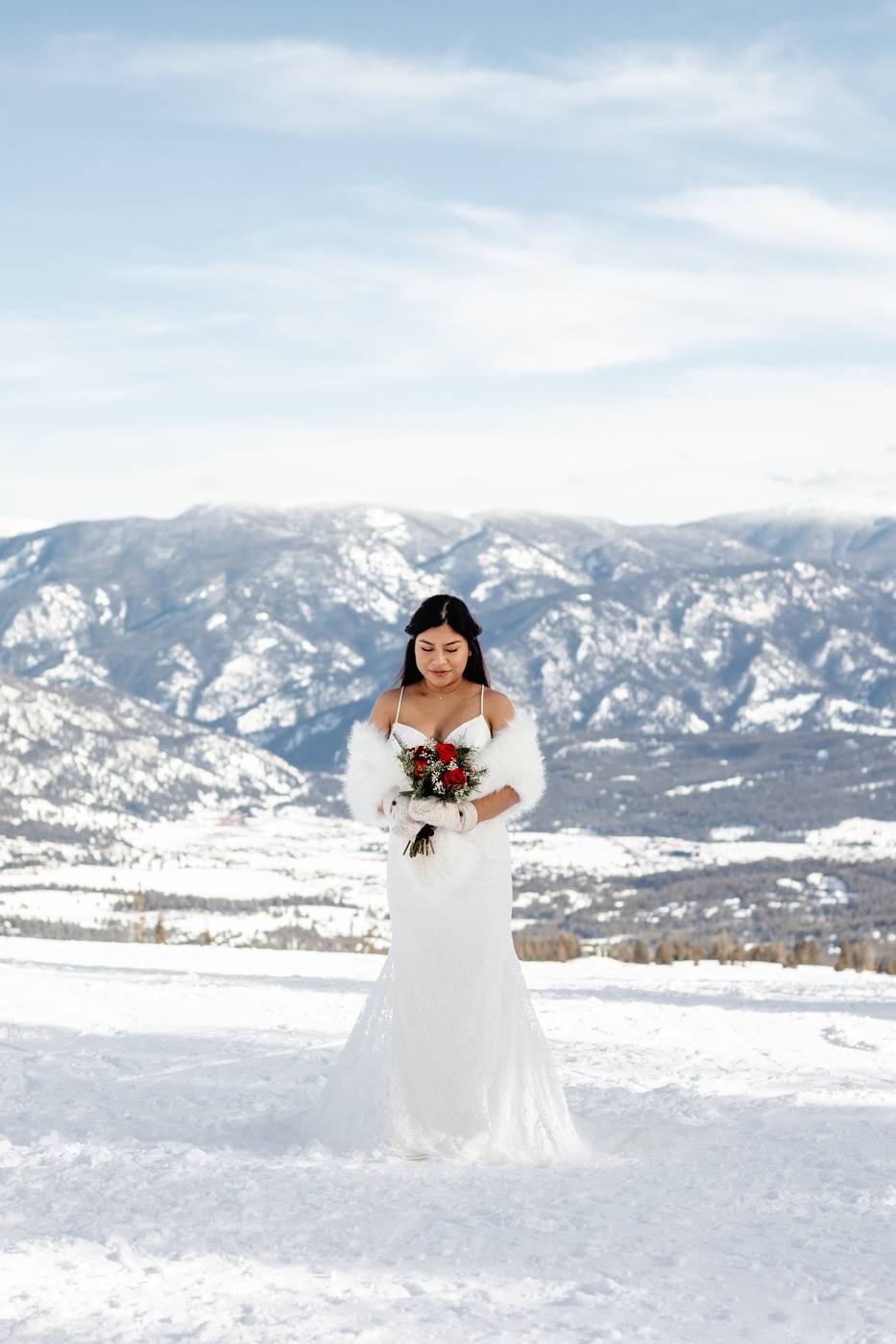 Woman in a wedding dress surrounded by snow and mountains