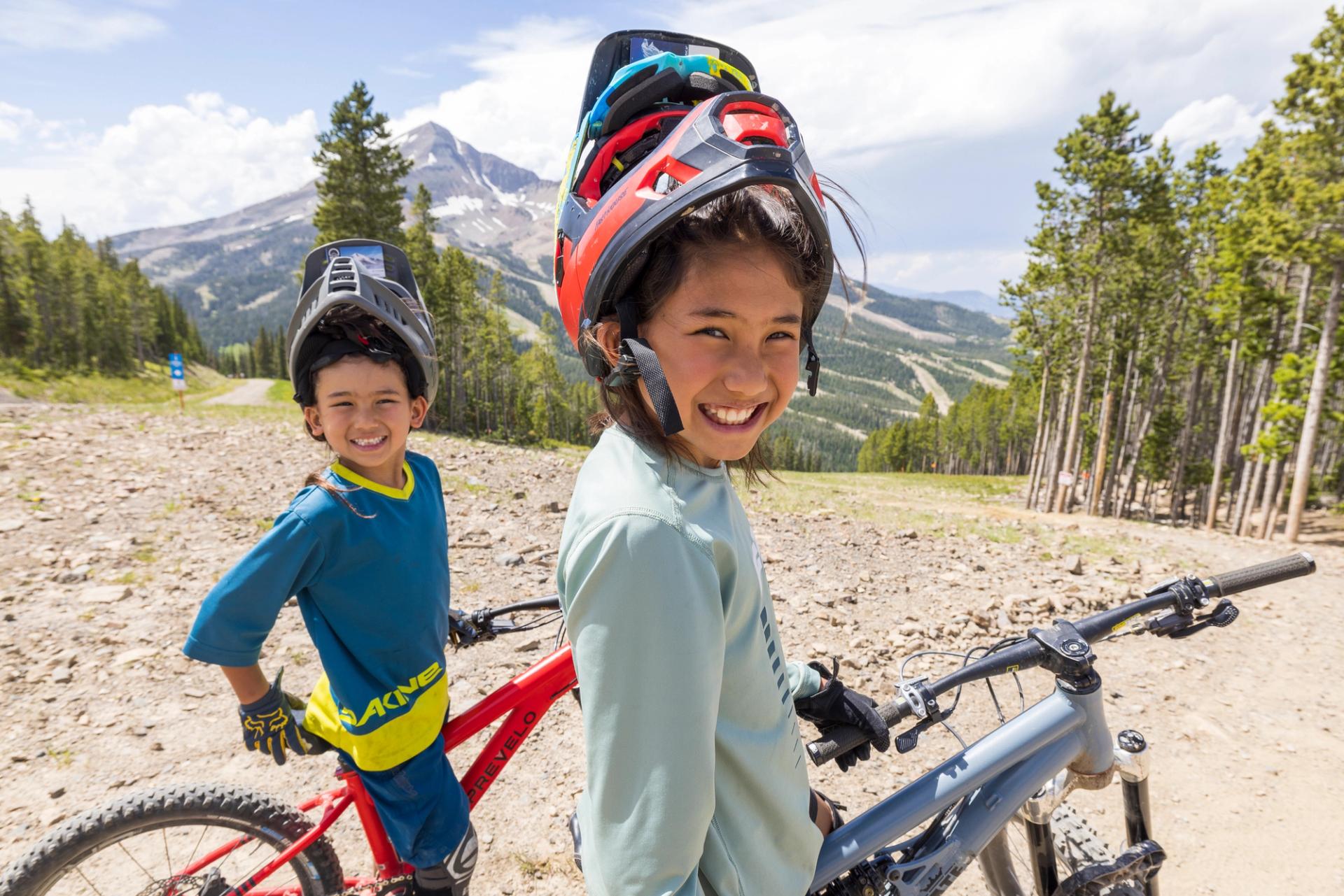 Two girls smiling with their mountain bikes