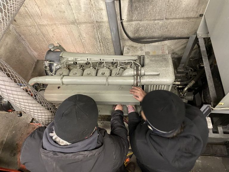 Two maintenance workers fix a motor