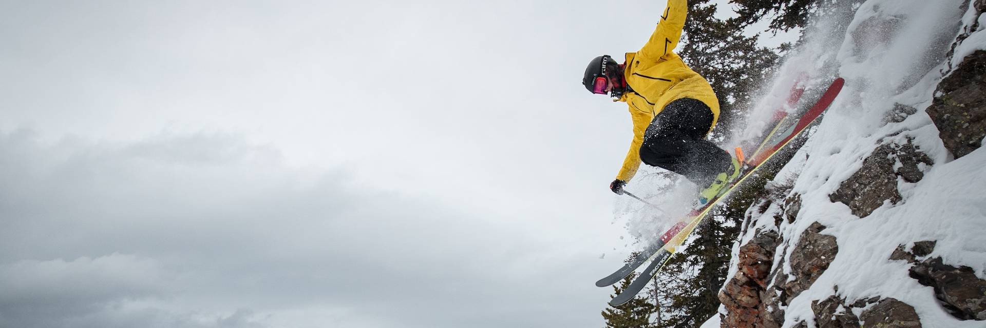 Freeride skier jumping off a small cliff