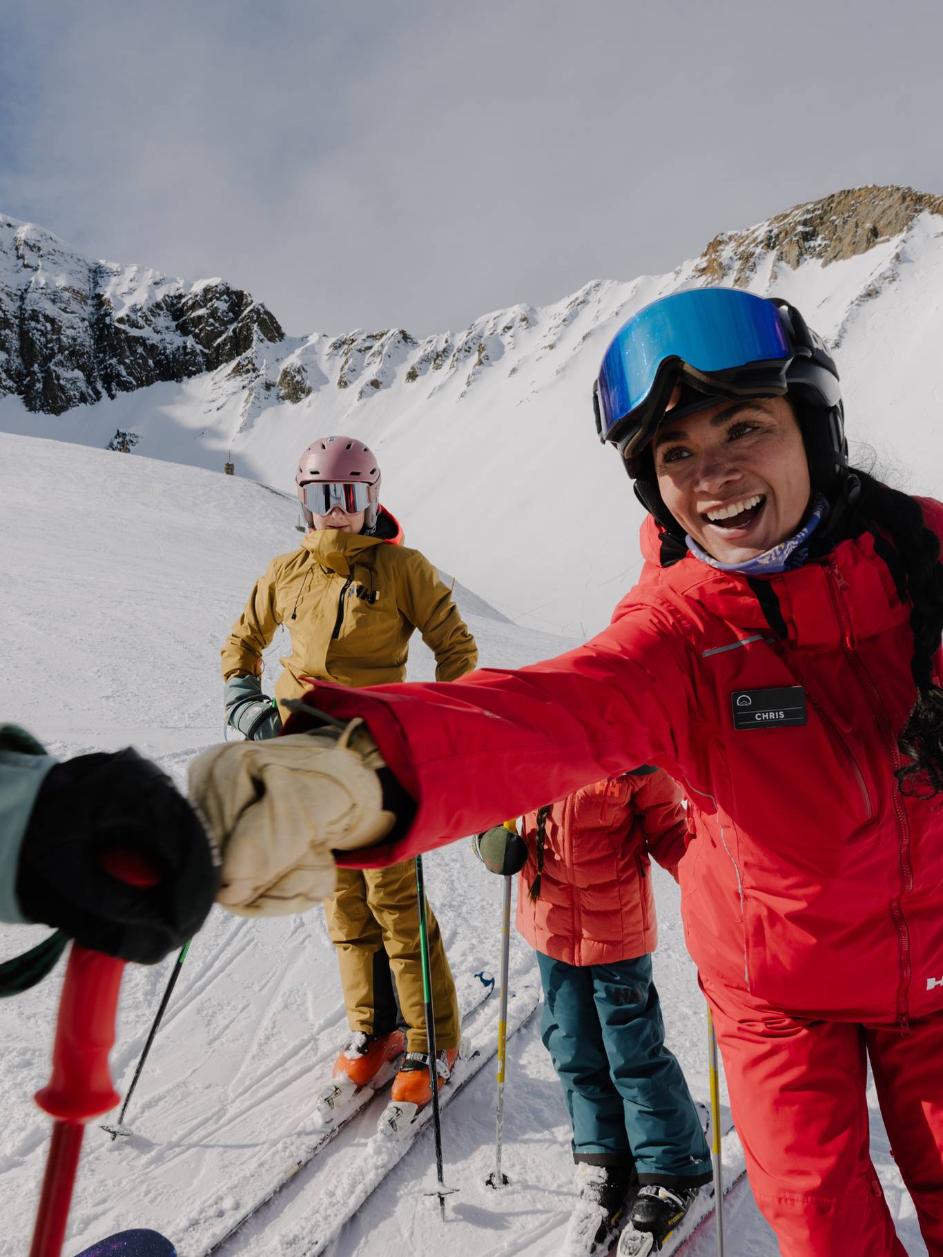 Ski instructor fist-bumbing another skier