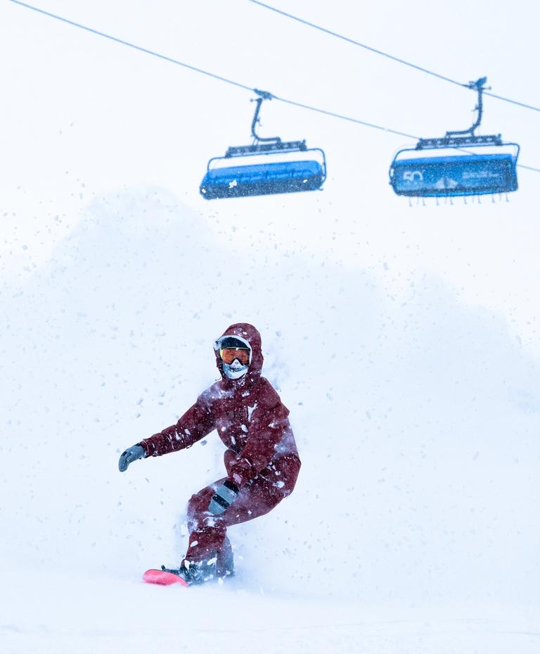 Snowboarder in powder in front of Ramcharger 8