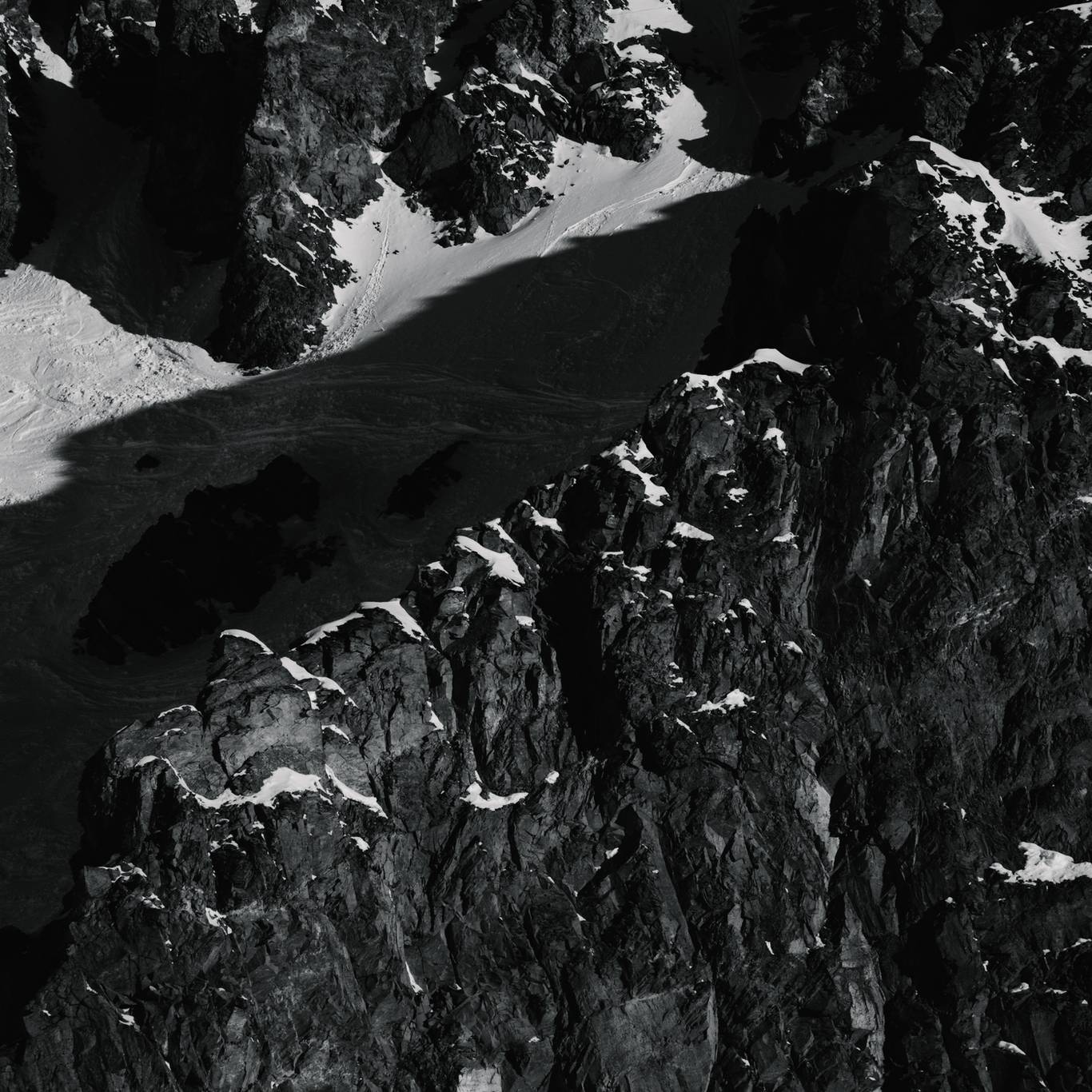 Black and white photo of cliffs covered in snow