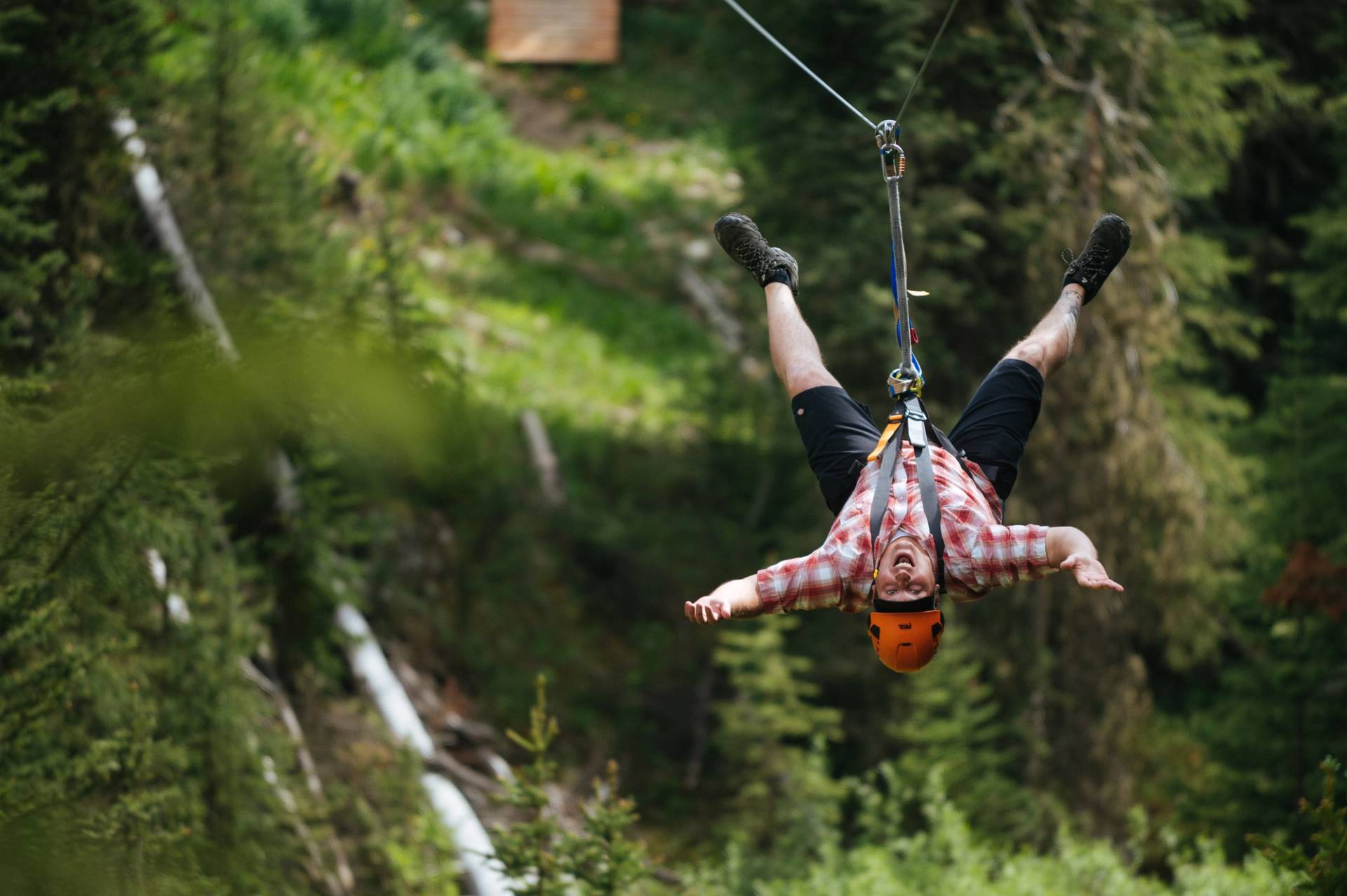 Man hanging upside-down on a zipline
