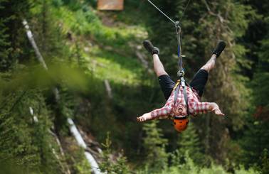 Man hanging upside-down on a zipline