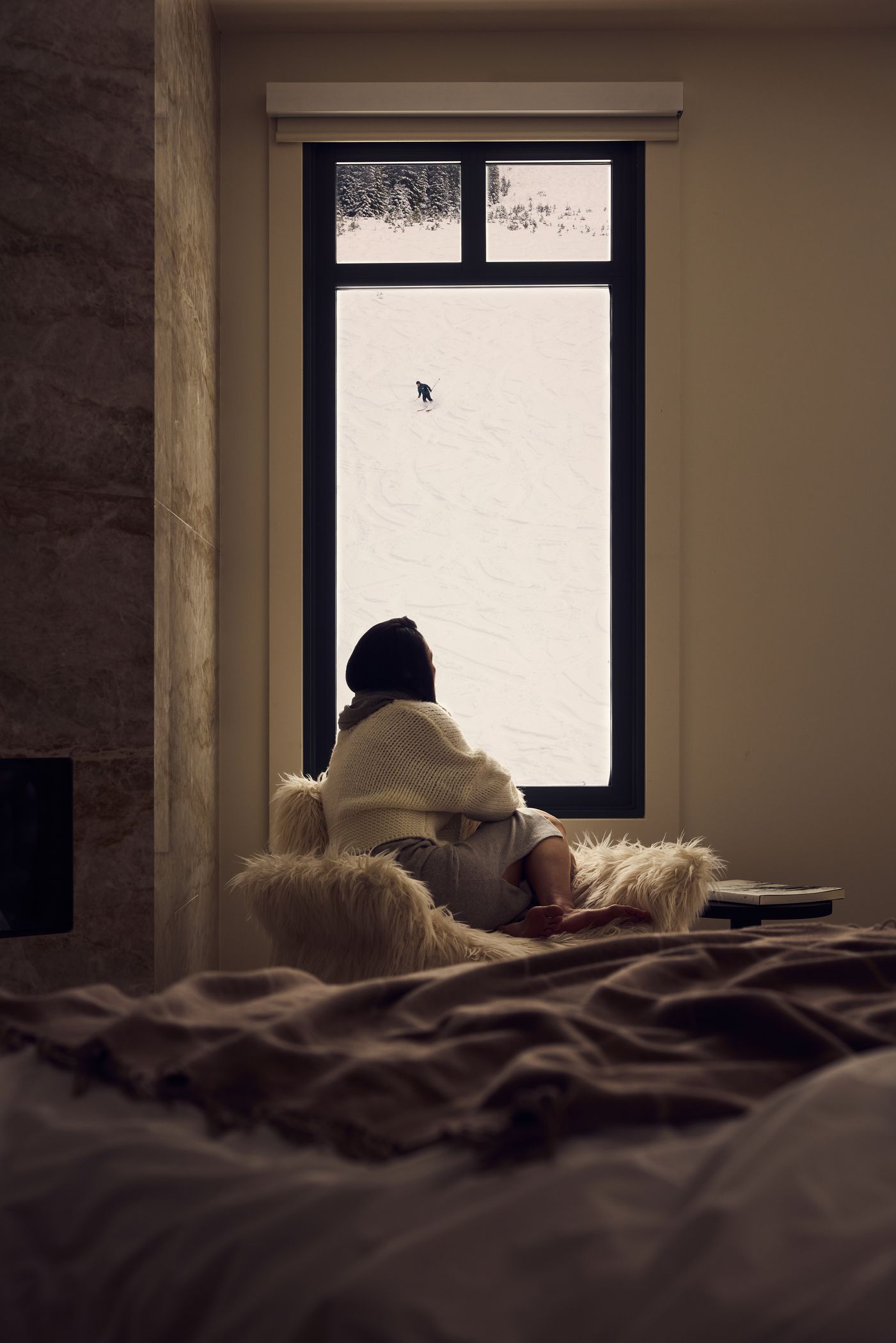Woman looking out a window at a skier