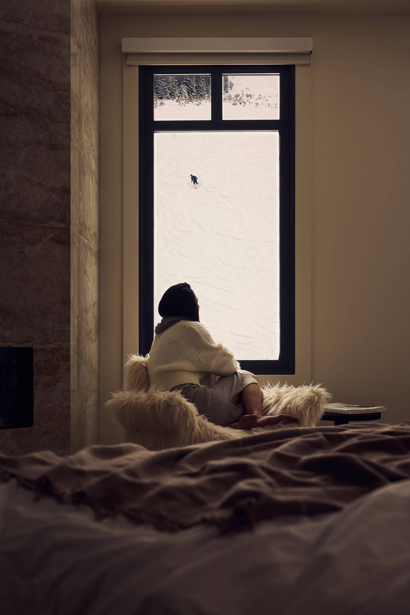 Woman looking out a window at a skier