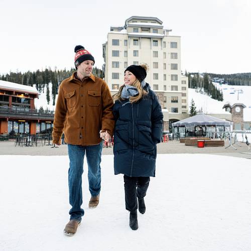 Couple walking through Mountain Village in winter