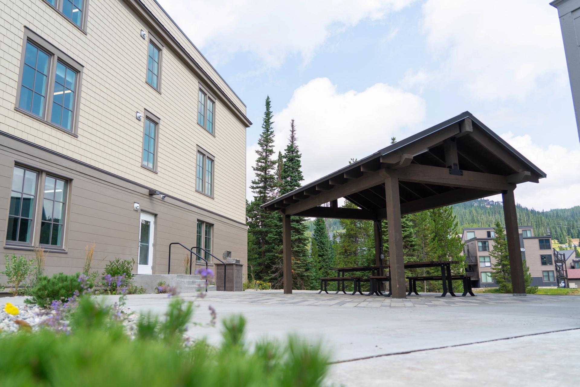 A small pavilion covers picnic tables in the outdoor patio space