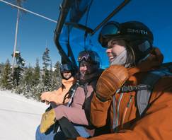 Snowboarders riding a chairlift
