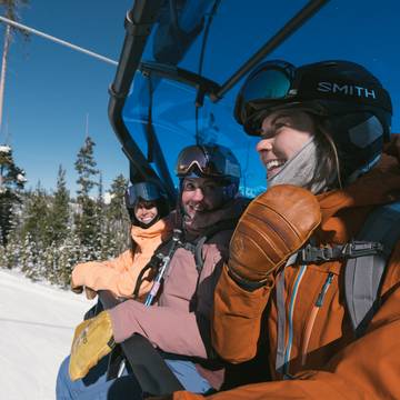 Snowboarders riding a chairlift