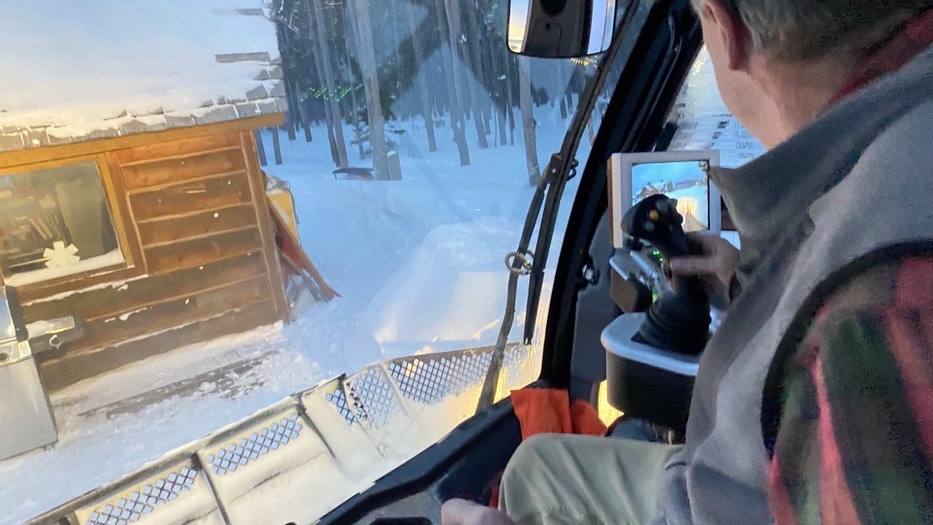 An over the shoulder shot of Ed driving the snowcat near the Andesite patrol shack