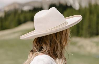 Woman in a felt hat looking out at the mountains
