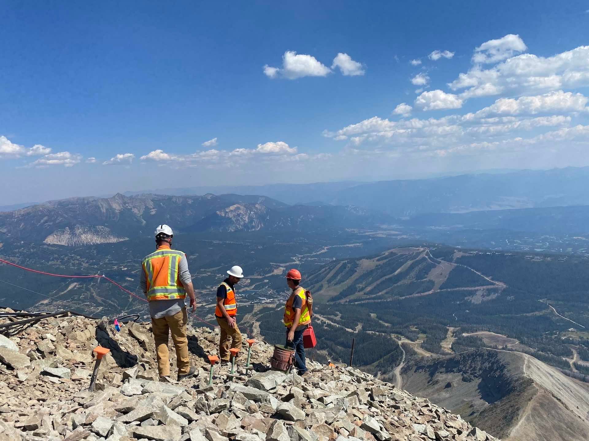 Chad and two construction workers chat on the ridge where the tram tower will be built