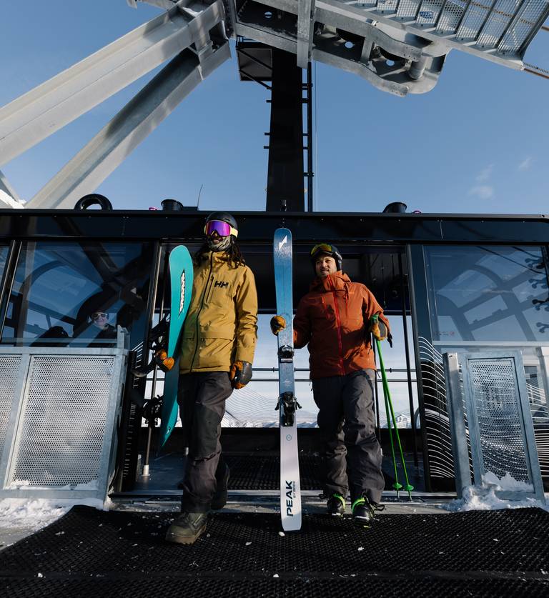 Skiers walking off of the Lone Peak Tram