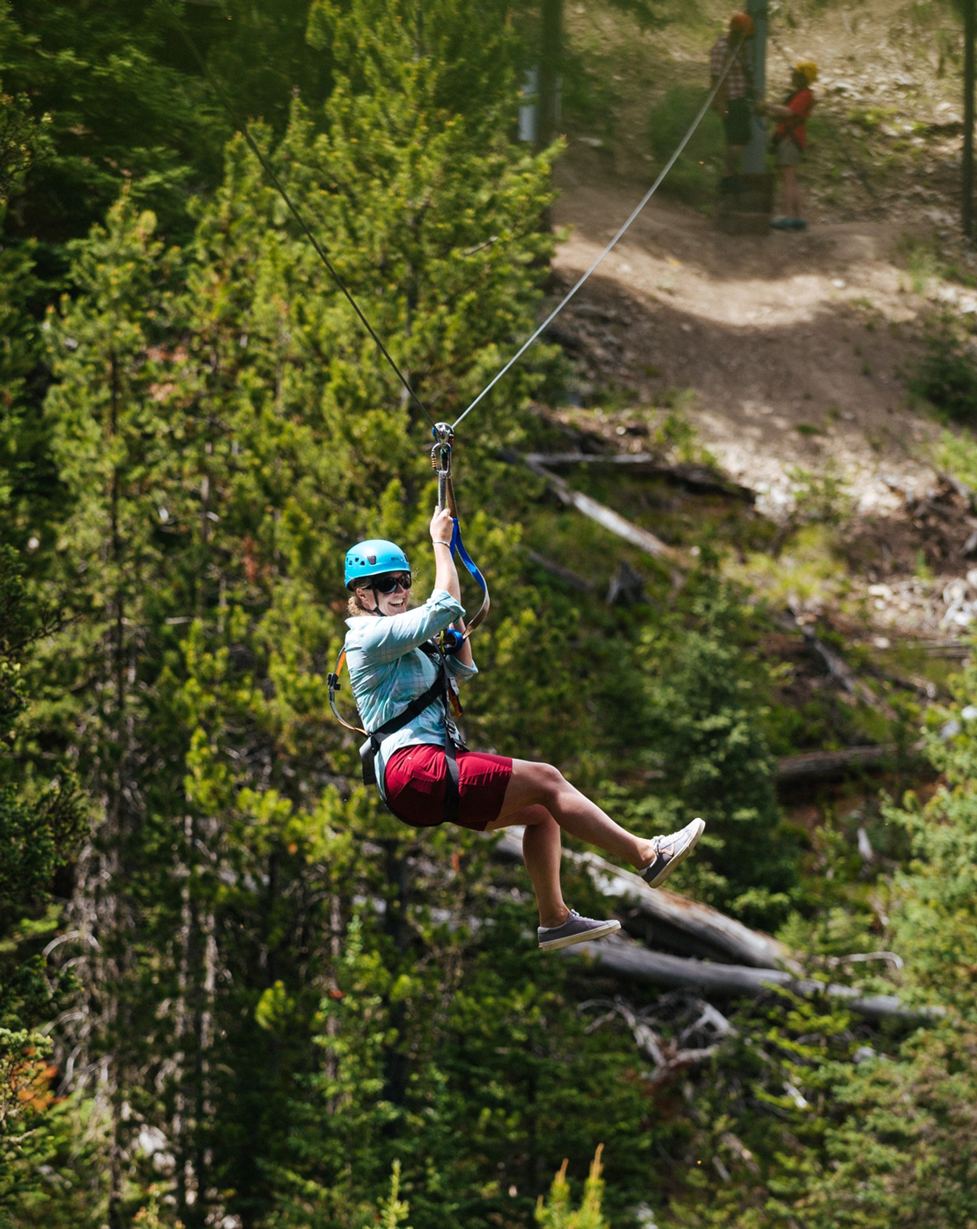 Woman on a zipline through the forest