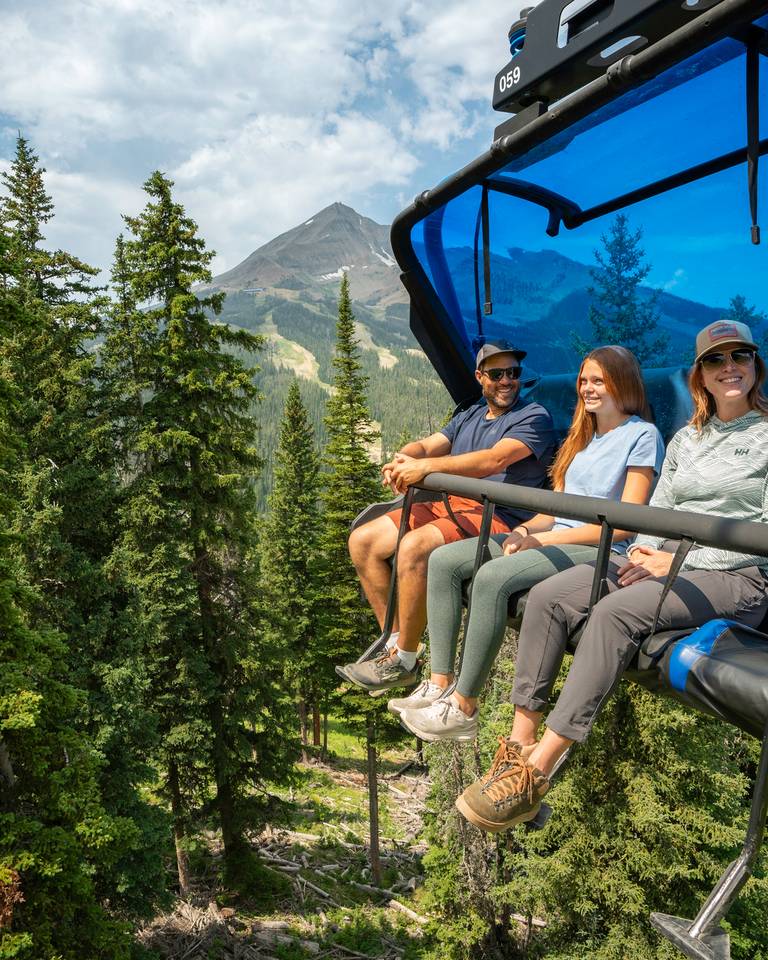 Family riding a chairlift in summer