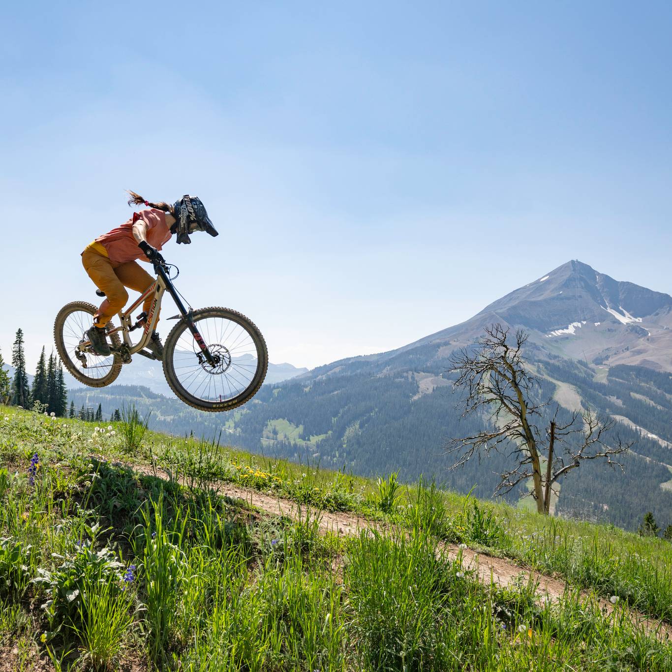 Mountain biker jumping in front of Lone Mountain