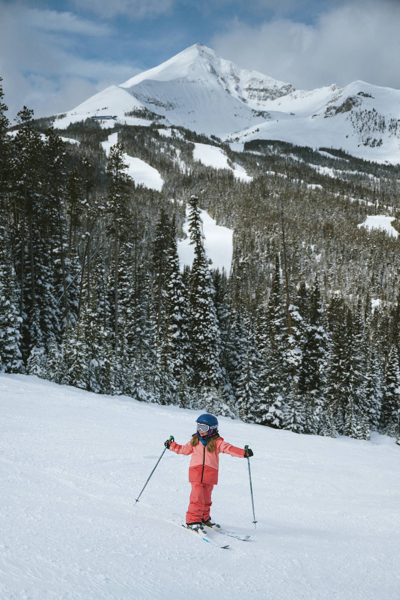 Girl in ski gear with Lone Peak in the background