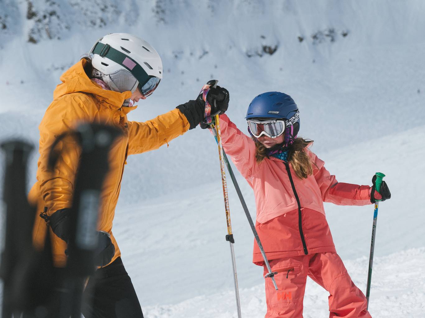 Girl and dad in ski gear high-fiving