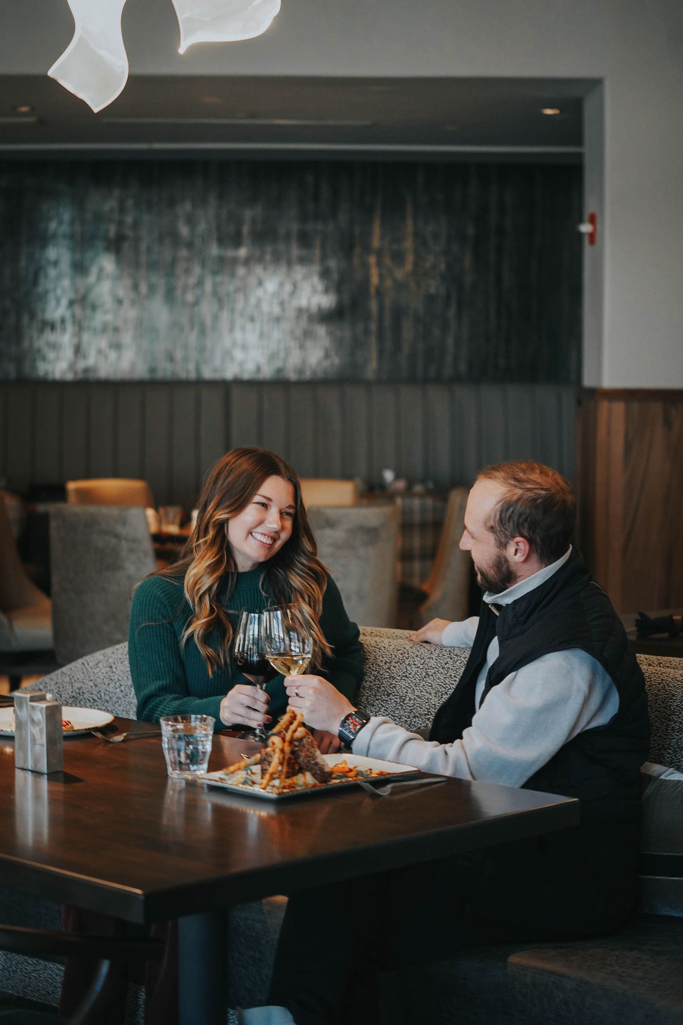 Couple cheersing wine glasses in a restaurant