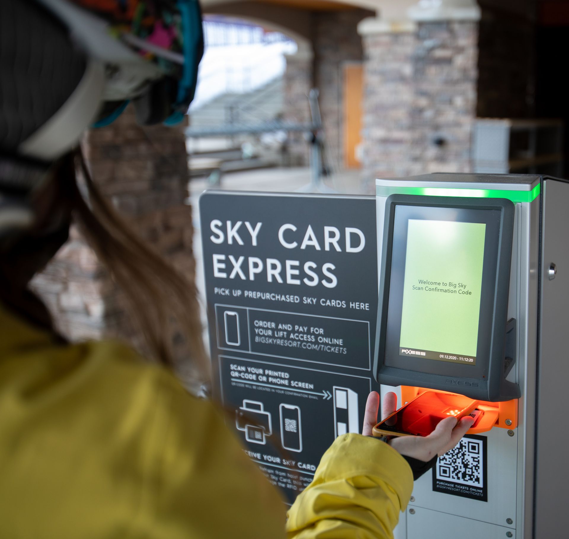 Woman picking up a lift ticket from a Sky Card Express box