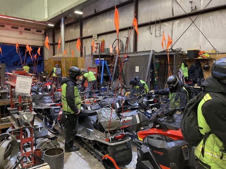 The lift maintenance team gets ready to board their snowmobiles in the morning