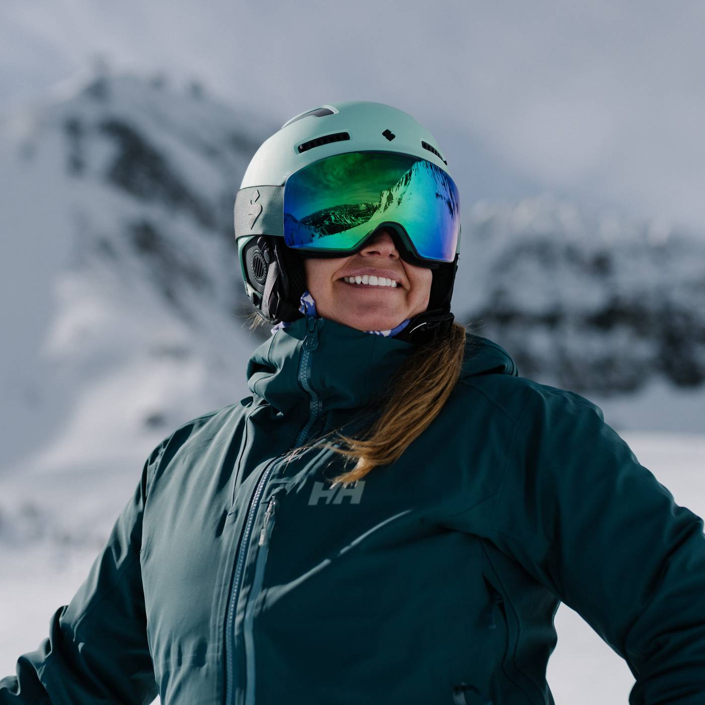 Woman smiling in ski gear with Lone Peak in the background