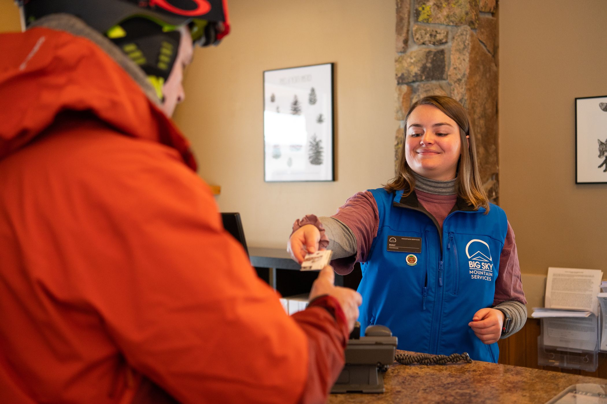 Woman handing a skier a ticket