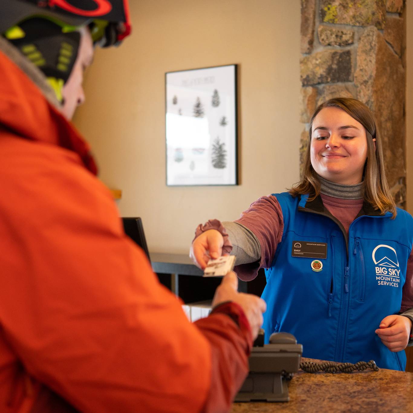 Woman handing a skier a ticket