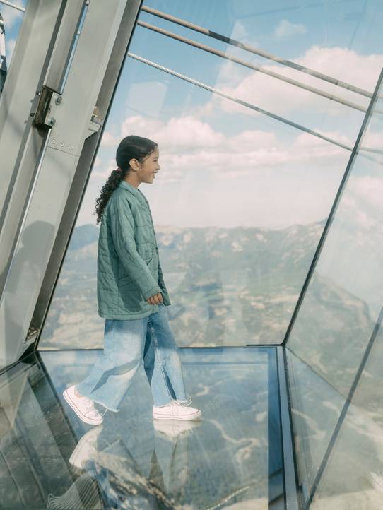 Girl walking out on the glass floor of Kirlciff