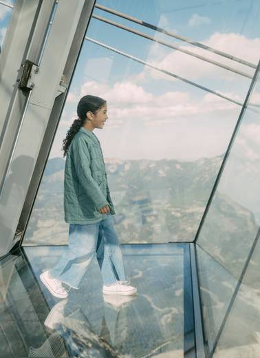 Girl walking out over the glass floor of Kircliff