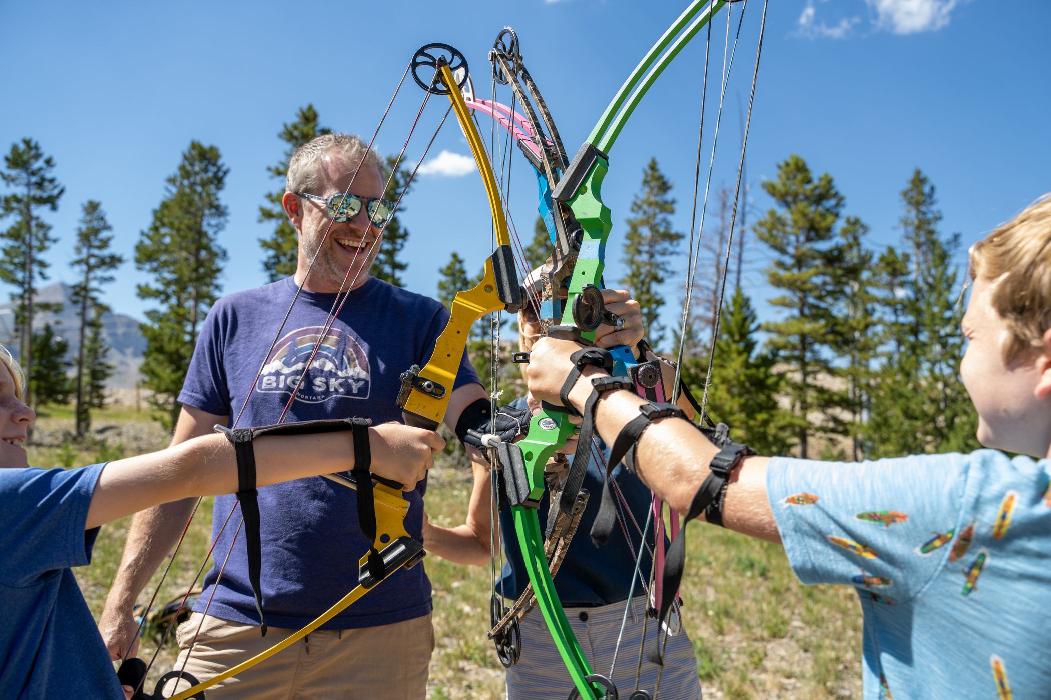 Family high-fiving with archery bows