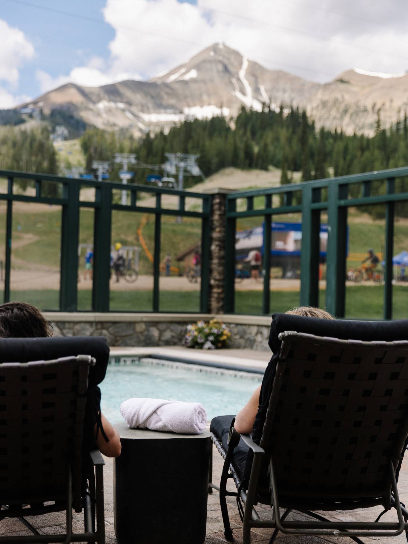Group of people sitting in a hot tub looking at Lone Mountain