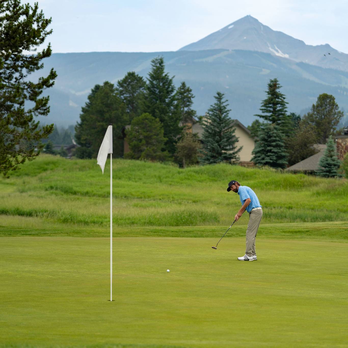 Golfer on a green with Lone Mountain in the background