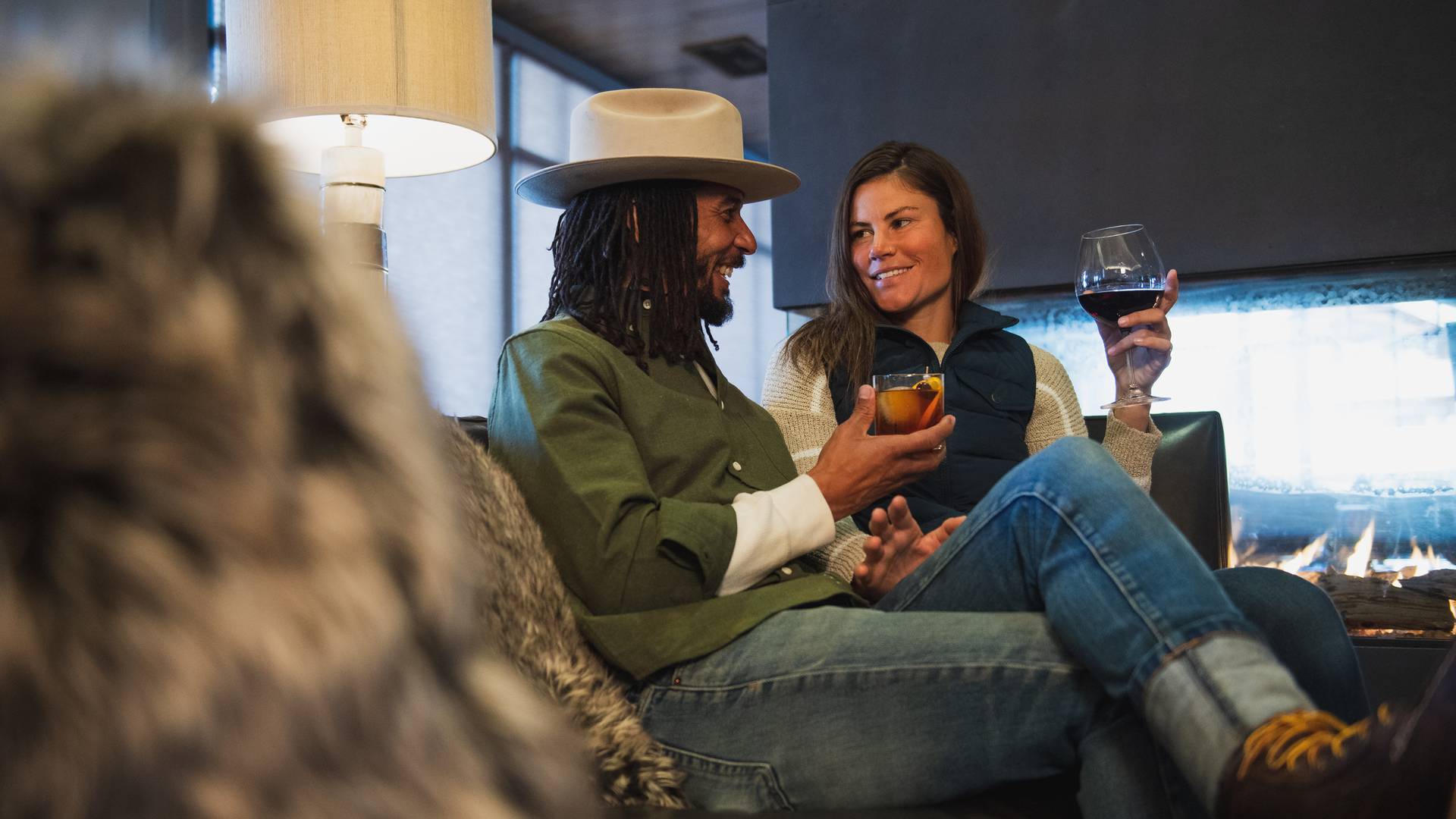 Couple with drinks by a fireplace
