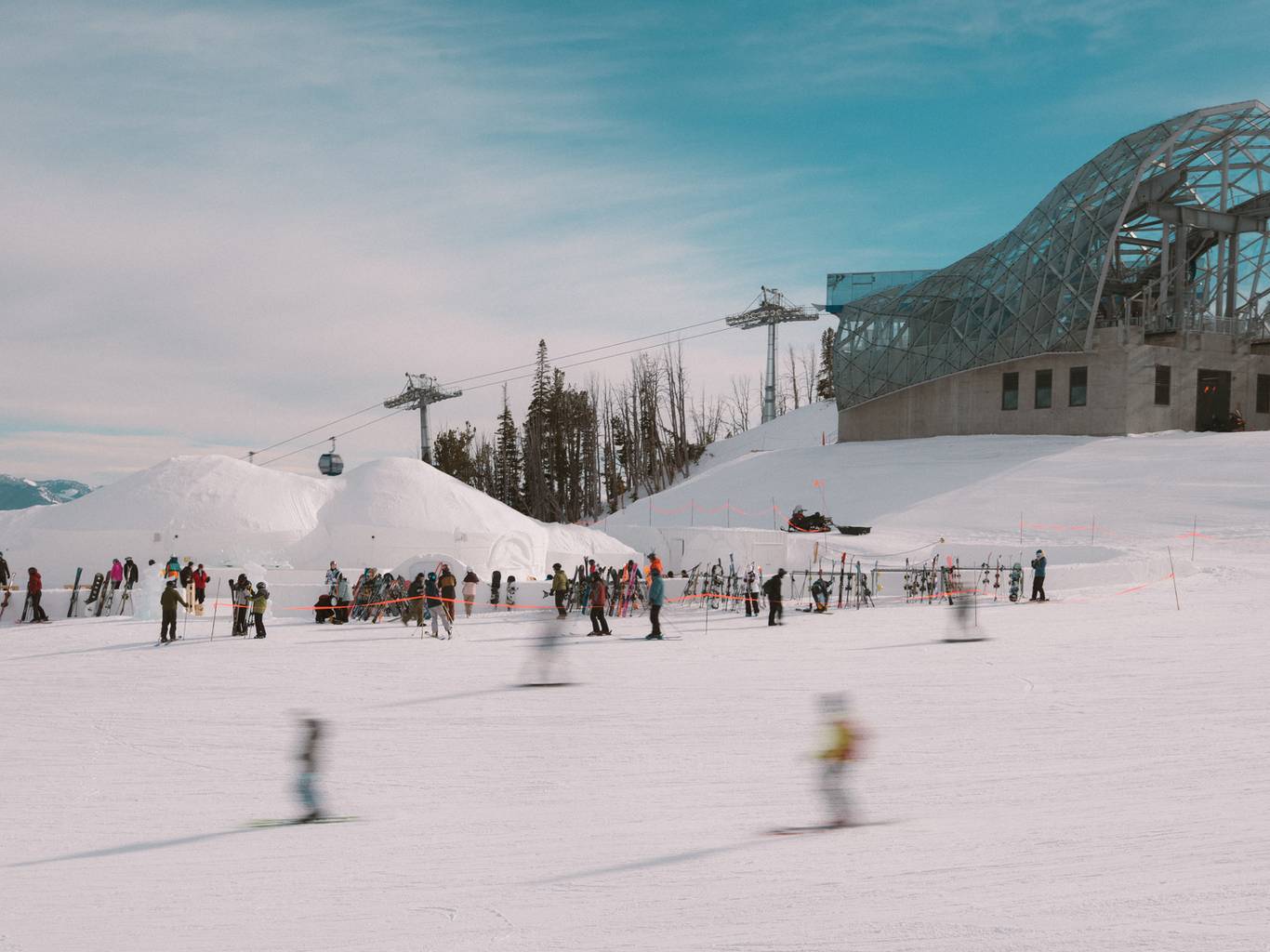 Skiers moving past the Iglu and Lone Peak Tram