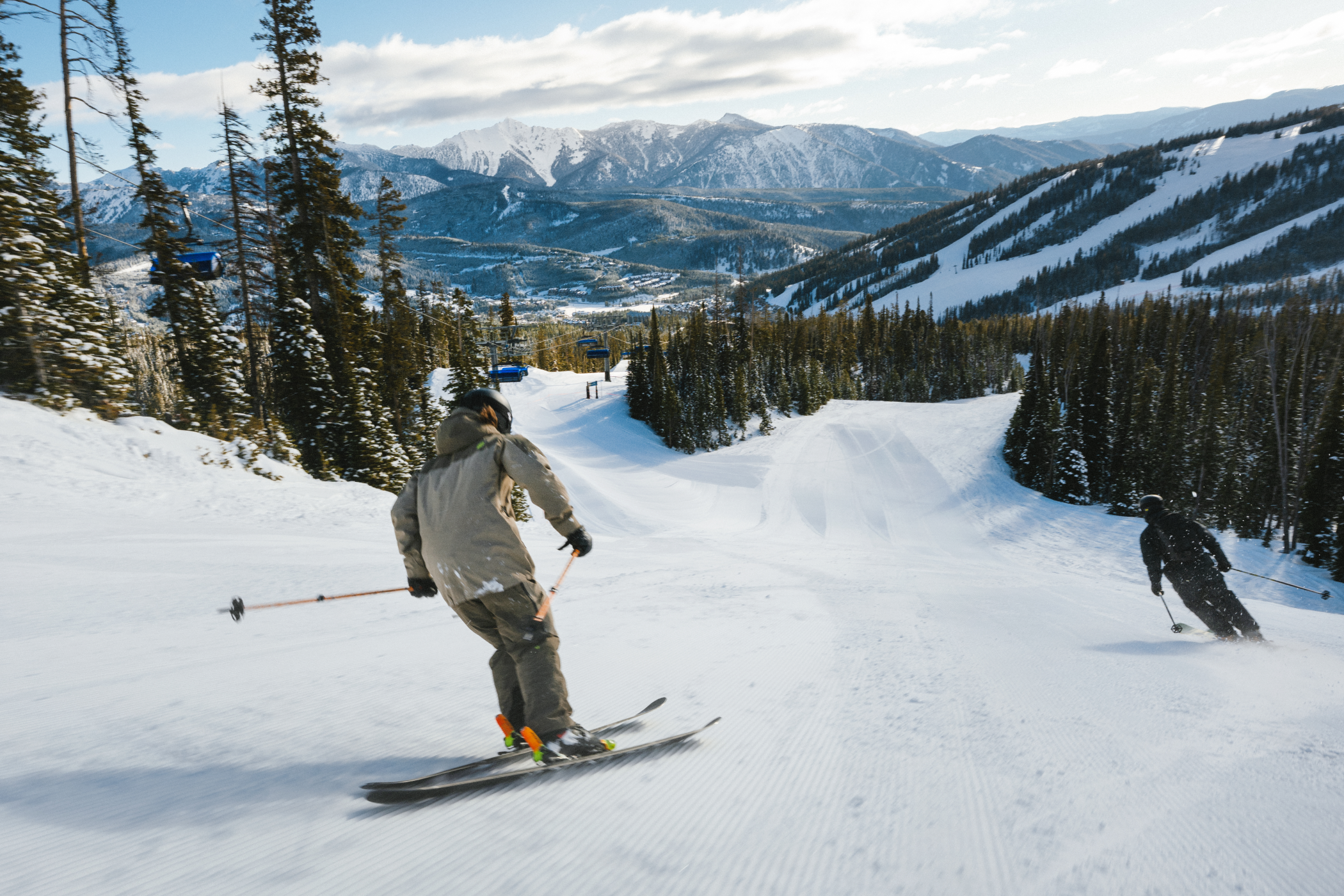 Two skiers on a groomed run